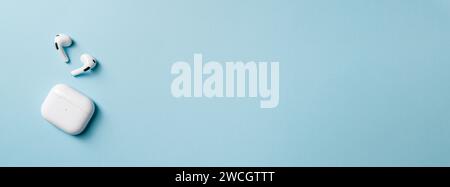 Casque sans fil et boîte de recharge, photographiés laissant un espace vide sur le côté droit de la photo Banque D'Images