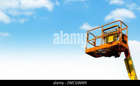 Élévateur à flèche télescopique orange sur fond bleu ciel livré au site de contrainte Banque D'Images