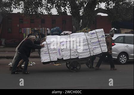 New Delhi, Delhi, INDE. 16 janvier 2024. Labourer transporte du boxex sur un cyclecart par une froide matinée à New Delhi, en Inde, le 16 2024 janvier (crédit image : © Deep Nair/ZUMA Press Wire) À USAGE ÉDITORIAL SEULEMENT! Non destiné à UN USAGE commercial ! Banque D'Images