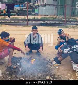 Au milieu du froid hivernal, les gens de la rue se rassemblent autour d'un feu scintillant, jouant avec des mélodies hivernales émouvantes. Cette image a été prise le 13 janvier 2024 Banque D'Images