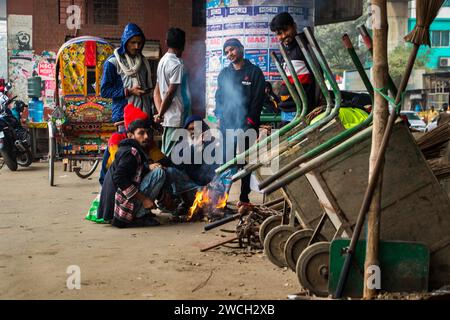 Au milieu du froid hivernal, les gens de la rue se rassemblent autour d'un feu scintillant, jouant avec des mélodies hivernales émouvantes. Cette image a été prise le 13 janvier 2024 Banque D'Images