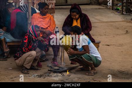 Au milieu du froid hivernal, les gens de la rue se rassemblent autour d'un feu scintillant, jouant avec des mélodies hivernales émouvantes. Cette image a été prise le 13 janvier 2024 Banque D'Images