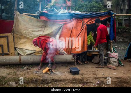 Au milieu du froid hivernal, les gens de la rue se rassemblent autour d'un feu scintillant, jouant avec des mélodies hivernales émouvantes. Cette image a été prise le 13 janvier 2024 Banque D'Images