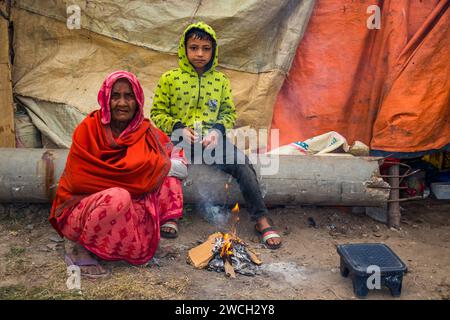 Au milieu du froid hivernal, les gens de la rue se rassemblent autour d'un feu scintillant, jouant avec des mélodies hivernales émouvantes. Cette image a été prise le 13 janvier 2024 Banque D'Images