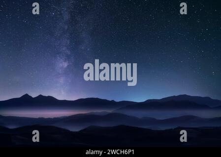 Ciel étoilé de nuit avec voie lactée au-dessus des montagnes. Banque D'Images