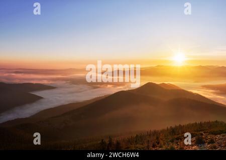 Matinée colorée magique dans les montagnes avec des nuages bas au lever du soleil. Beau paysage de montagne. Banque D'Images