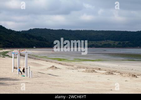 Saint-Michel-en-grève, France - juillet 25 2017 : des adolescents profitent de la balançoire à la plage de Saint-Michel-en-grève dans les Côtes-d'Armor, Bretagne. Banque D'Images