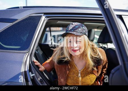 portrait de femme mature sortant de voiture portant un chapeau à la mode Banque D'Images
