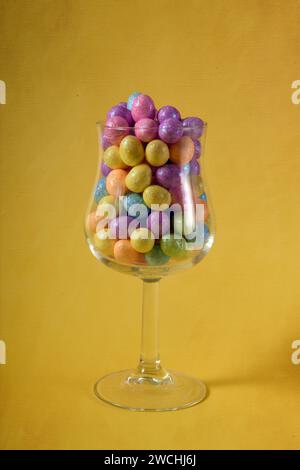 Photo verticale avec verre centré avec oeufs de Pâques de couleur pastel. Banque D'Images