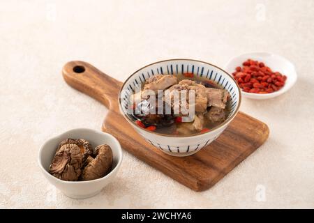 Délicieuse soupe de poulet aux champignons shiitake take taïwanais dans un bol sur fond de table blanc. Banque D'Images