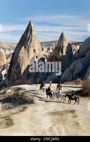 Les gens qui montent à cheval sur la Rose Red Valley en Cappadoce, Turquie. Destination célèbre pour les gens d'explorer les sites rocheux de Cappadoce. Banque D'Images