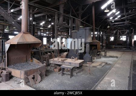 Intérieur du Blacksmith Shop où les hommes travaillaient, façonnant le métal chauffé à la main et à la machine, dans le Queen Victoria Museum à Inveresk Banque D'Images