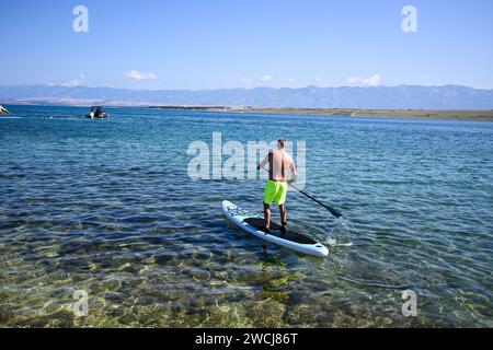 un gars rame sur un paddleboard. Banque D'Images