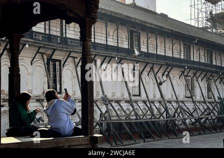 Katmandou, Bagmati, Népal. 16 janvier 2024. Des femmes prennent des photos près du bâtiment soutenu par des planches de bois, qui a été endommagé par le tremblement de terre de 2015 sur la place Hanumandhoka Durbar à Katmandou, au Népal, le 16 janvier 2024. Mardi, le Népal a célébré la 26e Journée de la sécurité contre le tremblement de terre, en commémoration de la dévastation causée par le tremblement de terre Népal-Bihar de 1934. Le Népal a fait face à un tremblement de terre le 2015 avril, également connu sous le nom de tremblement de terre de Gorkha, qui a tué près de 9 000 personnes et en a blessé plus de 22 000 et a récemment fait face à un autre tremblement de terre le 2023 novembre à Jajarkot, dans l'ouest du Népal. (Image de crédit : © Sunil Sharm Banque D'Images