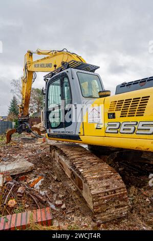 Berlin, Allemagne - 20 février 2022 : une excavatrice se trouve sur un chantier de construction où un ancien bâtiment résidentiel est en cours de démolition. Banque D'Images
