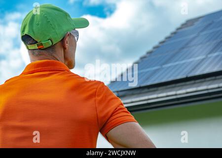 Installateur de panneaux solaires professionnels caucasiens prenant le dernier regard final sur un système photovoltaïque nouvellement installé. Banque D'Images