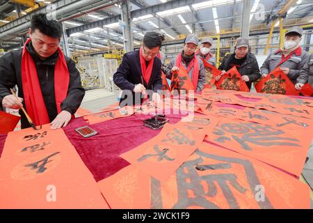 Pékin, province chinoise du Zhejiang. 16 janvier 2024. Des calligraphes bénévoles écrivent des couplets du Festival du printemps pour des travailleurs lors d'un atelier dans la ville de Huzhou, dans la province du Zhejiang, dans l'est de la Chine, le 16 janvier 2024. Divers événements sont organisés à travers le pays pour célébrer le nouvel an lunaire chinois, qui tombe le 10 février de cette année. Crédit : XIe Shangguo/Xinhua/Alamy Live News Banque D'Images