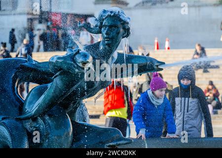 Londres, Royaume-Uni. 16 janvier 2024. Les passants sont bien enveloppés car le temps hivernal très froid gèle l'eau dans les fontaines de Trafalgar Square. Crédit : Guy Bell/Alamy Live News Banque D'Images