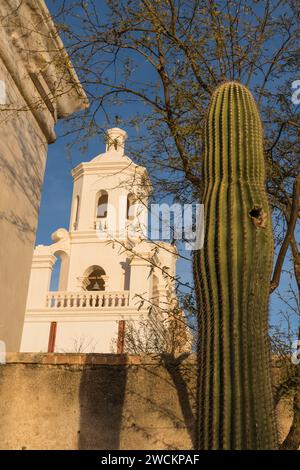 Un cactus saguaro avec un trou de nid d'oiseau et le clocher ouest de la Mission San Xavier del bac, Tucson Arizona. Banque D'Images