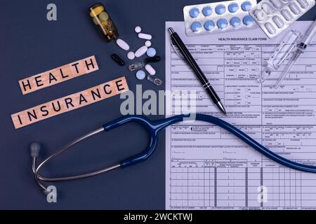 Formulaire d'assurance maladie réclamation avec stéthoscope, pilules et injection sur la table. Assurance médicale, risque santé, payer pour le concept de santé. Banque D'Images