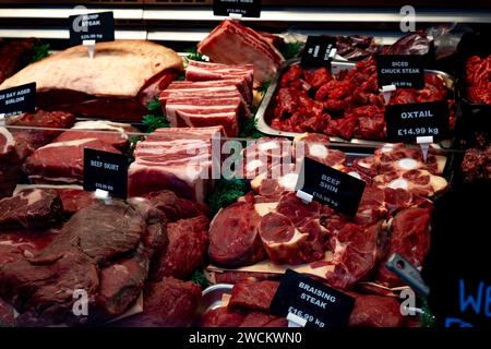 Une exposition de différentes coupes de bœuf dans une boucherie à Saffron Walden, Essex, y compris du steak de croupe et de la queue de bœuf. Banque D'Images