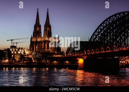 Cologne, Allemagne. 16 janvier 2024. La cathédrale et le pont Hohenzollern sont illuminés le soir. Crédit : Oliver Berg/dpa/Alamy Live News Banque D'Images