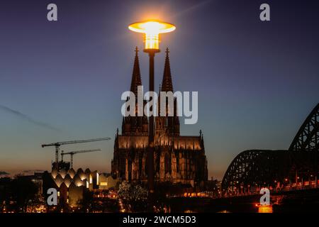 Cologne, Allemagne. 16 janvier 2024. Une lanterne brille sur les tours de la cathédrale le soir. Crédit : Oliver Berg/dpa/Alamy Live News Banque D'Images