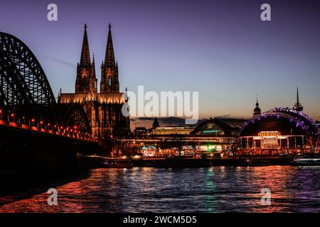 Cologne, Allemagne. 16 janvier 2024. La cathédrale et le pont Hohenzollern sont illuminés le soir. Crédit : Oliver Berg/dpa/Alamy Live News Banque D'Images