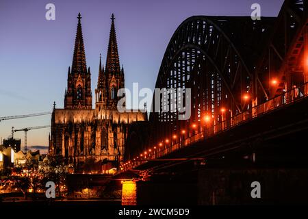 Cologne, Allemagne. 16 janvier 2024. La cathédrale et le pont Hohenzollern sont illuminés le soir. Crédit : Oliver Berg/dpa/Alamy Live News Banque D'Images