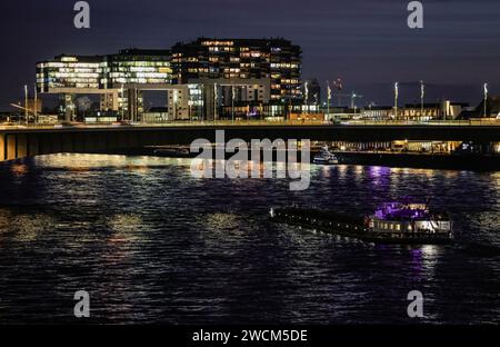 Cologne, Allemagne. 16 janvier 2024. Un navire traverse le Rhin devant le Kranhäuser dans la soirée. Crédit : Oliver Berg/dpa/Alamy Live News Banque D'Images