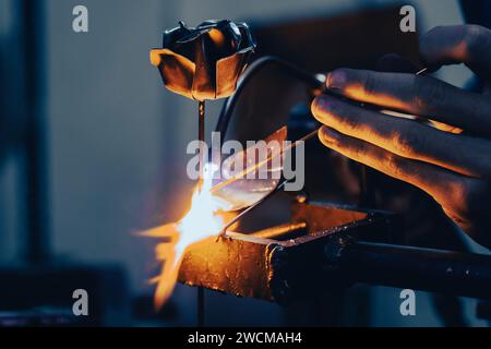 Un artisan soudant une rose métallique Banque D'Images