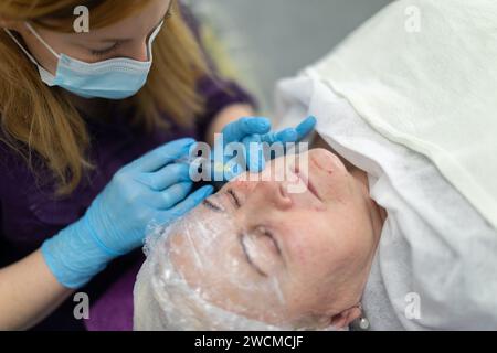 Effectuer la mésothérapie à l'aiguille dans un salon de beauté professionnel. Banque D'Images