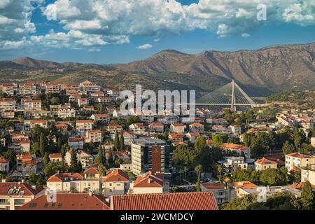 Surplombant les toits en terre cuite de Dubrovnik, avec un pont suspendu moderne sur fond montagneux. Banque D'Images