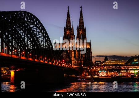 Cologne, Allemagne. 16 janvier 2024. La cathédrale et le pont Hohenzollern sont illuminés le soir. Crédit : Oliver Berg/dpa/Alamy Live News Banque D'Images