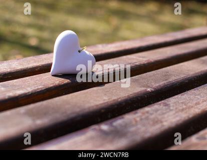 Un coeur en pierre repose sur un banc en bois Banque D'Images