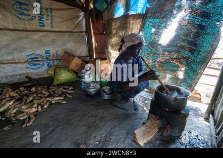 Ouganda, Adjumani. Une femme cuisine sur son poêle de fortune dans un camp de réfugiés. Usage éditorial uniquement. Banque D'Images