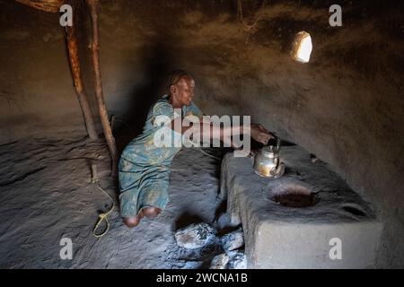 Ouganda, Adjumani. Une réfugiée sud-soudanaise cuisine dans sa cuisine. Usage éditorial uniquement. Banque D'Images