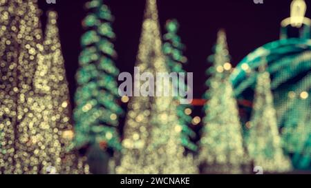 Sapin de Noël orné de lumières dorées bokeh floues créant une ambiance chaleureuse et festive pendant les vacances d'hiver. Tentures douces, espace pour te Banque D'Images