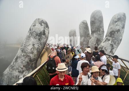 Danang, Vietnam - 27 juin 2023 : le pont d'or est soulevé par deux mains géantes dans la station touristique sur la colline de Ba Na Banque D'Images