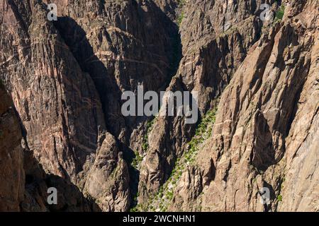 Roches massives dans l'ombre et la lumière dans les profondeurs du Black Canyon du parc national de Gunnison River, Colorado, USA. Banque D'Images