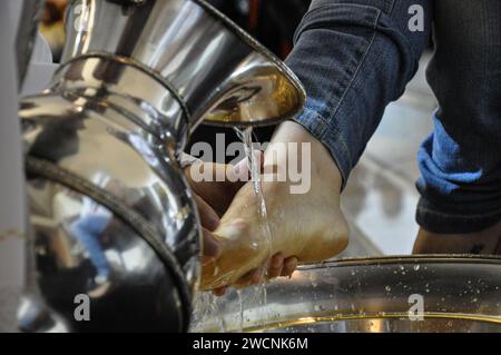 Dans la cérémonie de lavage des pieds, le jeudi matin, le prêtre lave le pied d'une femme, mettant à jour l'action de Jésus qui a lavé les pieds de ses disciples. Banque D'Images