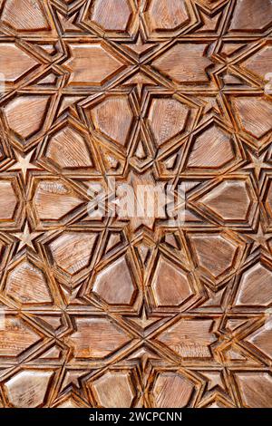 Détail de sculpture géométrique de style islamique avec des formes d'étoiles complexes d'une porte d'une mosquée, fragment architectural oriental traditionnel artisanal bac Banque D'Images