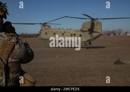 L'hélicoptère CH-47 Chinook américain atterrit à la zone d'atterrissage pour ramasser des soldats affectés à la batterie Cobra, 3e bataillon, 320e régiment d'artillerie de campagne, au cours de l'entraînement à l'exercice d'ascenseur à Mihail Kogalniceanu, Roumanie, le 11 janvier 2024. Les unités rotatives déployées en Europe s'entraînent en permanence pour déployer rapidement des forces prêtes au combat sur le théâtre des opérations afin de soutenir l'alliance de l'OTAN et de projeter des forces ensemble. (Photo de la Réserve de l'armée américaine par le SPC Precious Scott) Banque D'Images