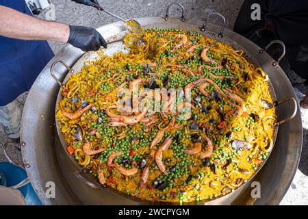 Paella mexicaine avec plusieurs ingrédients (riz, crevettes, pois, crustacés et tomates) en cours de préparation dans un grand wok 3. Banque D'Images