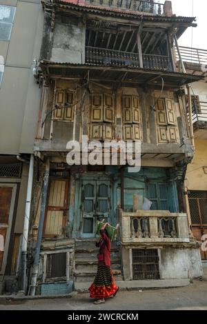 Ahmedabad, Inde - 10 janvier 2024 : une femme portant une petite table à travers la vieille ville d'Ahmedabad, en Inde. Banque D'Images