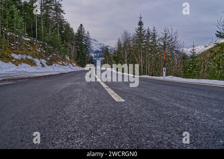 Une route de montagne pittoresque s'étendant à travers un paysage enveloppé d'arbres Banque D'Images