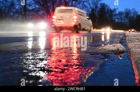 Stuttgart, Allemagne. 17 janvier 2024. Les voitures roulent sur une route humide pendant l'heure de pointe du matin dans des conditions hivernales. Il y a de la neige au bord. Crédit : Bernd Weißbrod/dpa/Alamy Live News Banque D'Images