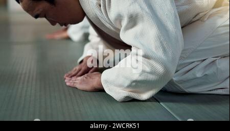 Homme asiatique, étudiant ou arc dans le dojo pour le respect, le salut ou l'honneur à maîtriser à la salle de gym intérieure. Gros plan d'une personne masculine ou d'un entraîneur de karaté qui s'incline Banque D'Images