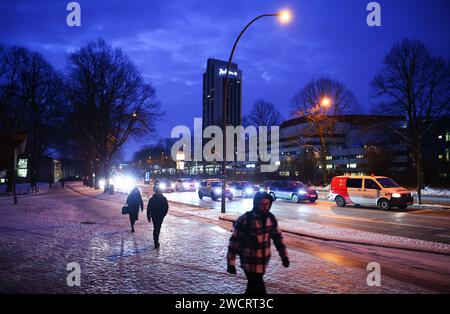 Hambourg, Allemagne. 17 janvier 2024. Les piétons marchent sur un vélo glacé et un sentier pédestre à côté d'une route principale dans des conditions hivernales dans le centre-ville. La neige et la glace noire obstruent la circulation dans de nombreuses régions d'Allemagne. Crédit : Christian Charisius/dpa/Alamy Live News Banque D'Images