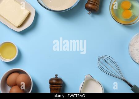Cadre fait d'ingrédients de pâte et fouetter sur fond bleu clair, pose à plat. Espace pour le texte Banque D'Images